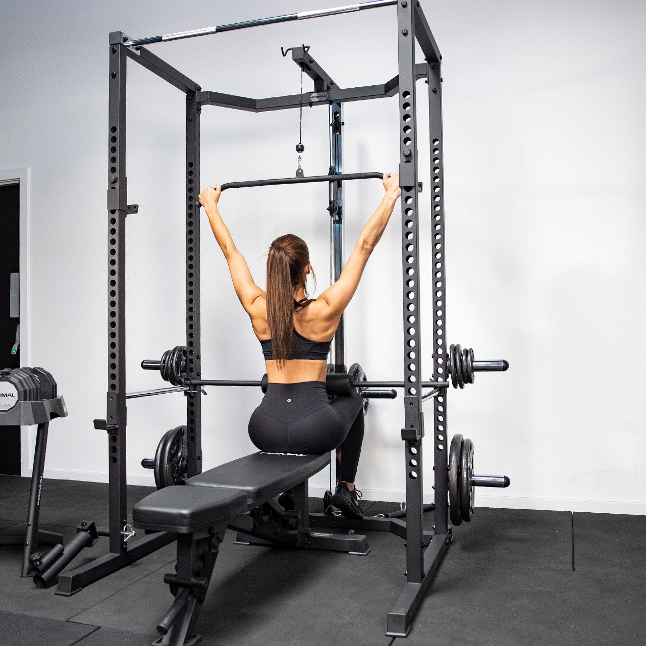 An athlete using the lat pulldown attachment on a home gym rack.