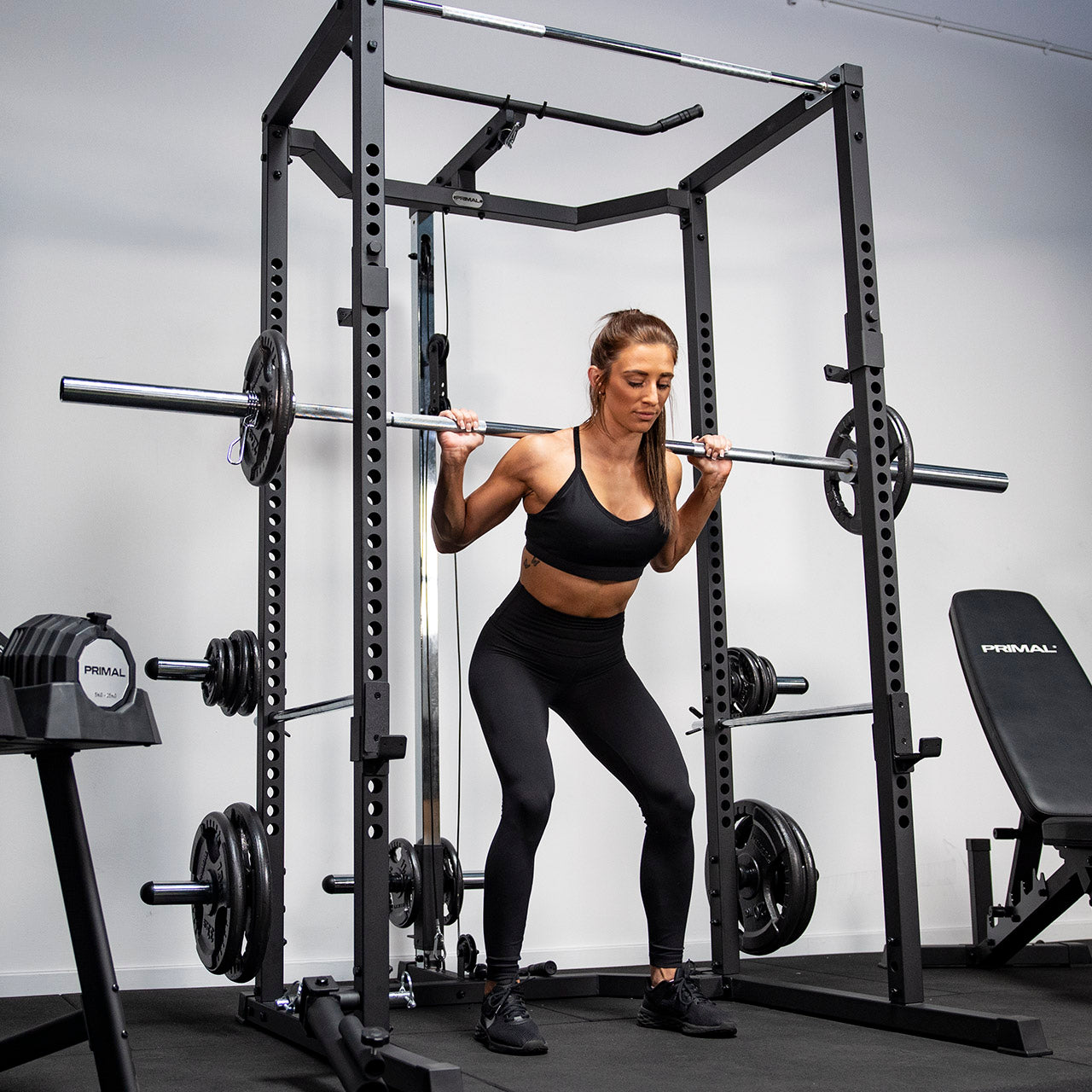 An athlete performing a squat with a loaded barbell in a home gym rack.