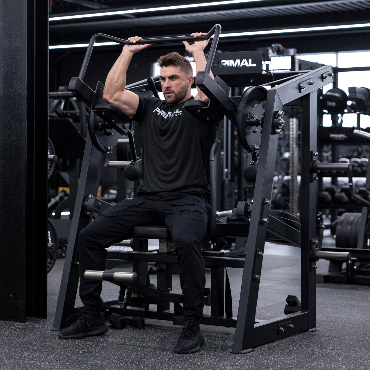 Angled view of athlete using plate-loaded pullover machine.