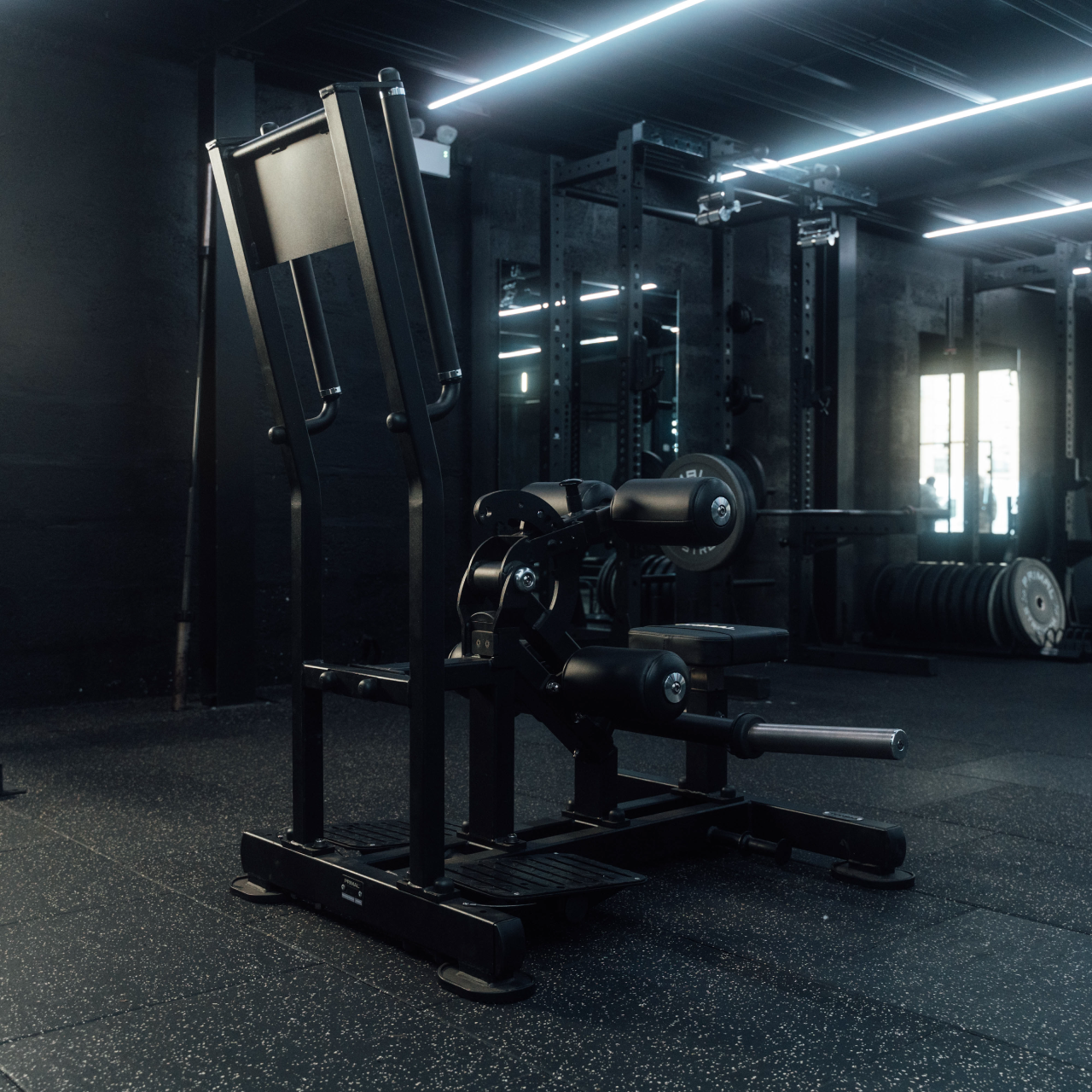 Angled view of plate-loaded standing hip thrust machine in gym.