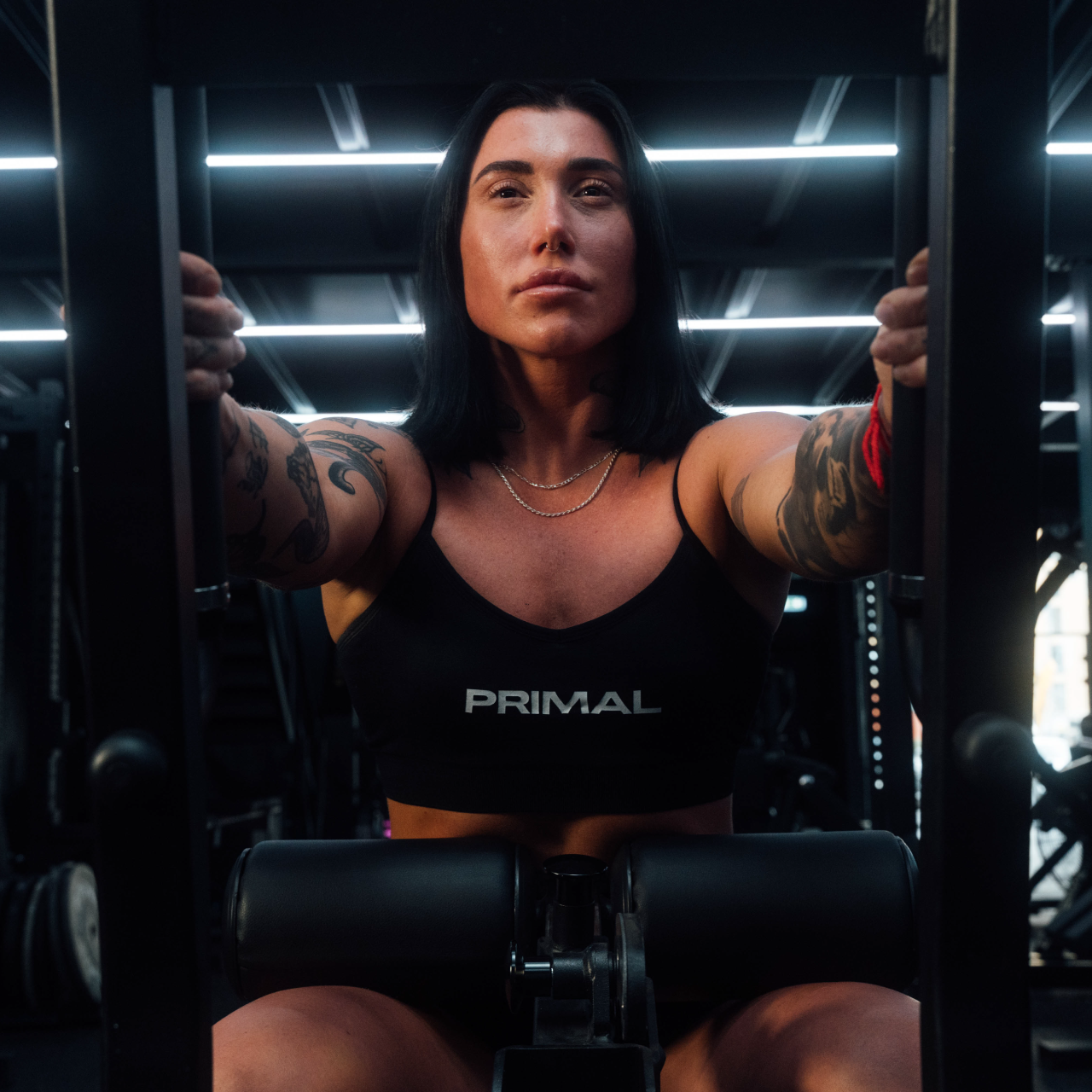 Close up view of athlete using plate-loaded standing hip thrust machine.