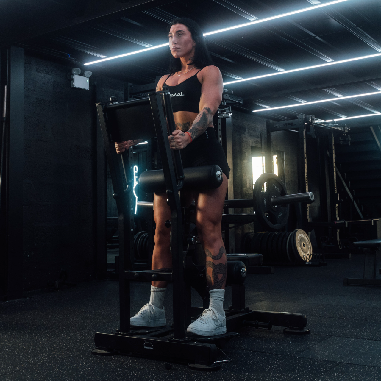 Athlete using plate-loaded standing hip thrust machine.