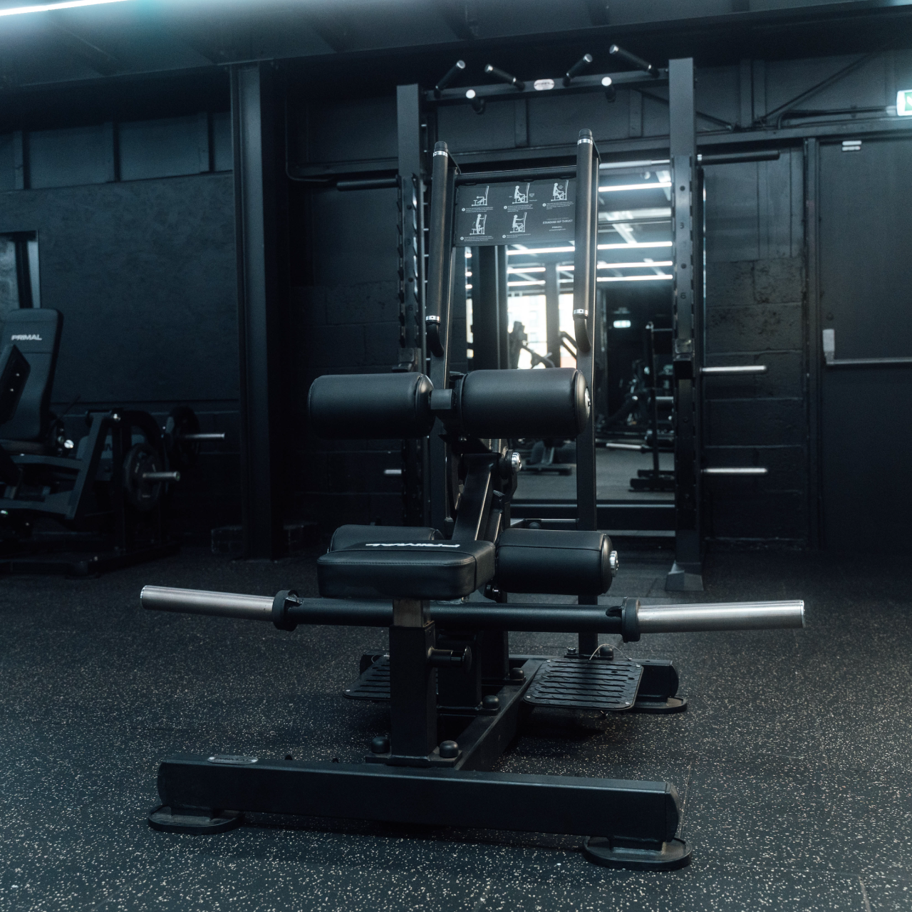 Front on view of plate-loaded standing hip thrust machine in gym.
