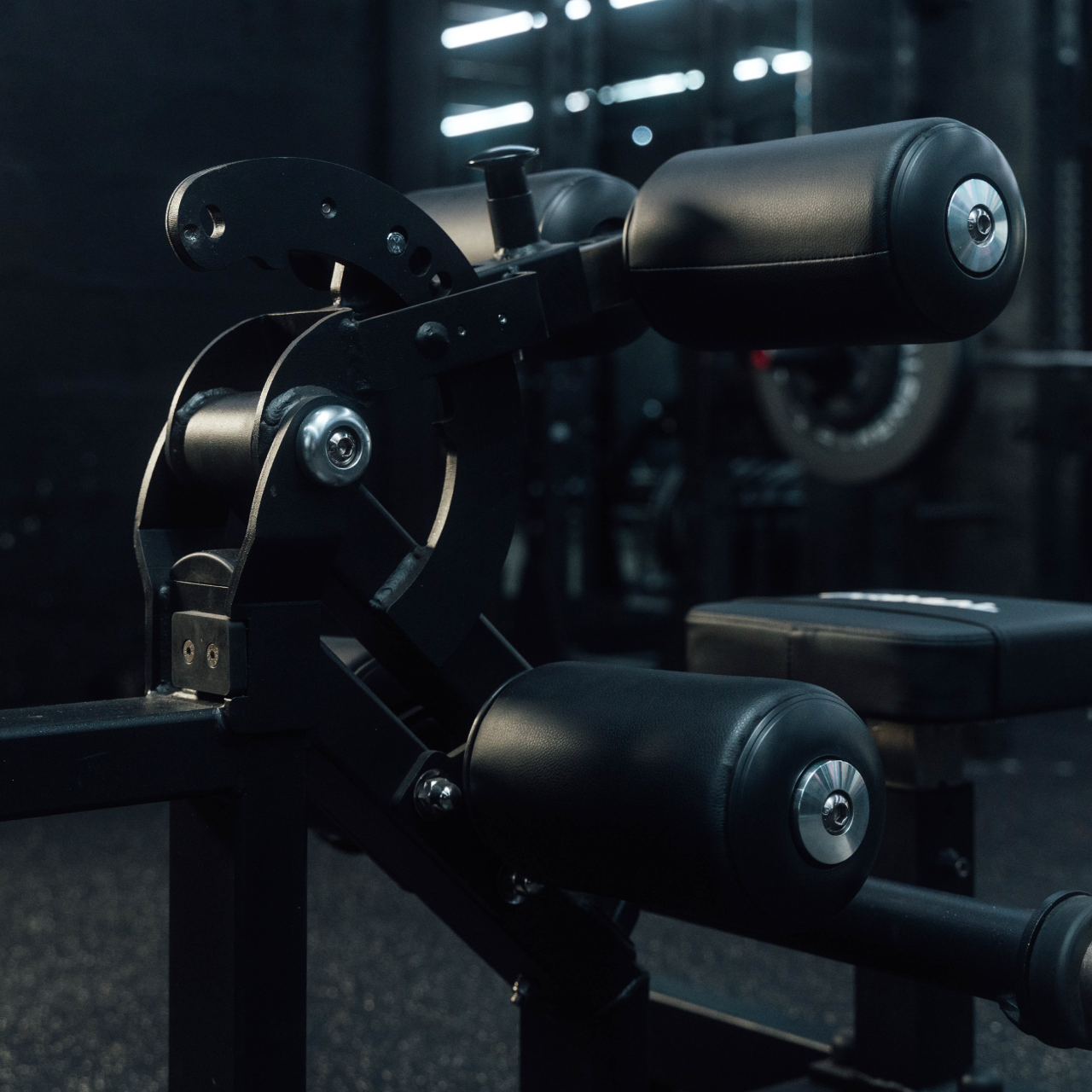 Close up view of adjustable pads on plate-loaded standing hip thrust machine.