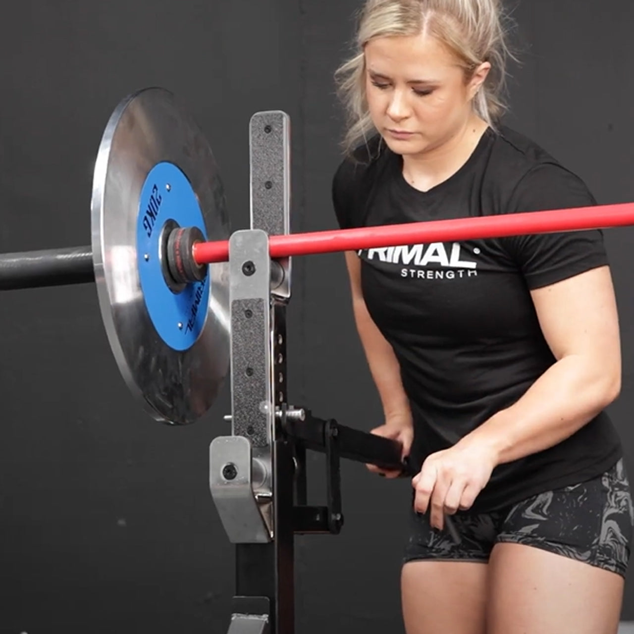 An athlete adjusting the barbell spotter arms on a weight bench.