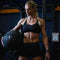 Athletic woman holding a wall ball in a gym setting.