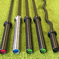 A selection of barbells lying on gym astroturf.