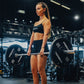 Woman lifting a barbell with Primal weights in a gym setting
