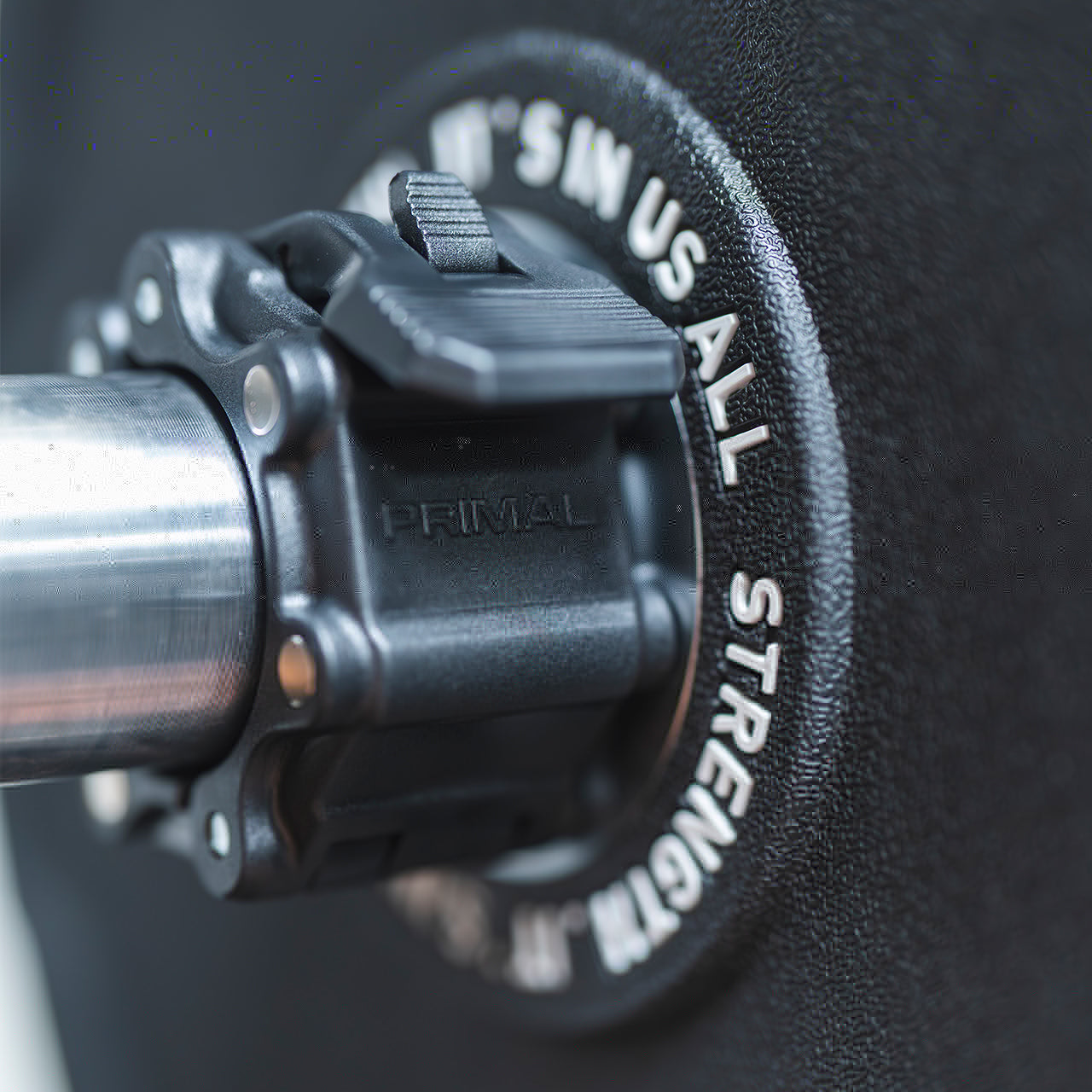 Close up view of a magnetic lockjaw collar securing a bumper plate in place on a barbell.