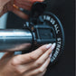 Close up view of a magnetic lockjaw collar securing a bumper plate in place on a barbell.