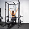An athlete using the lat pulldown attachment on a home gym rack.