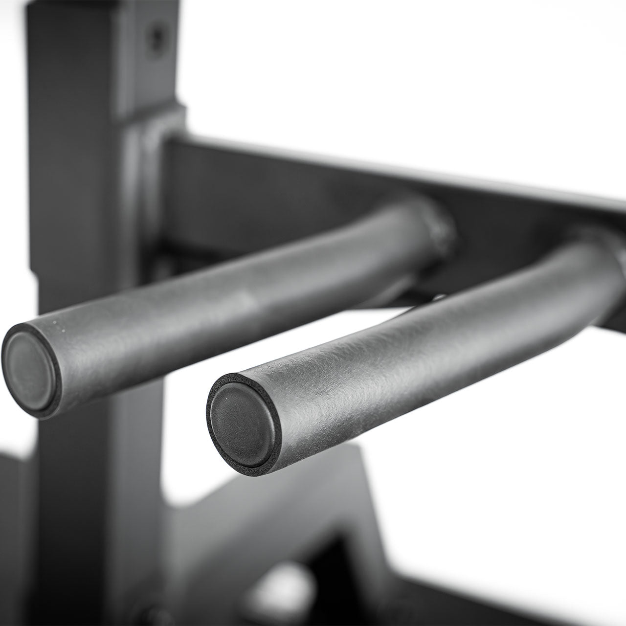 A close up of a dip handle attachment on a half rack.