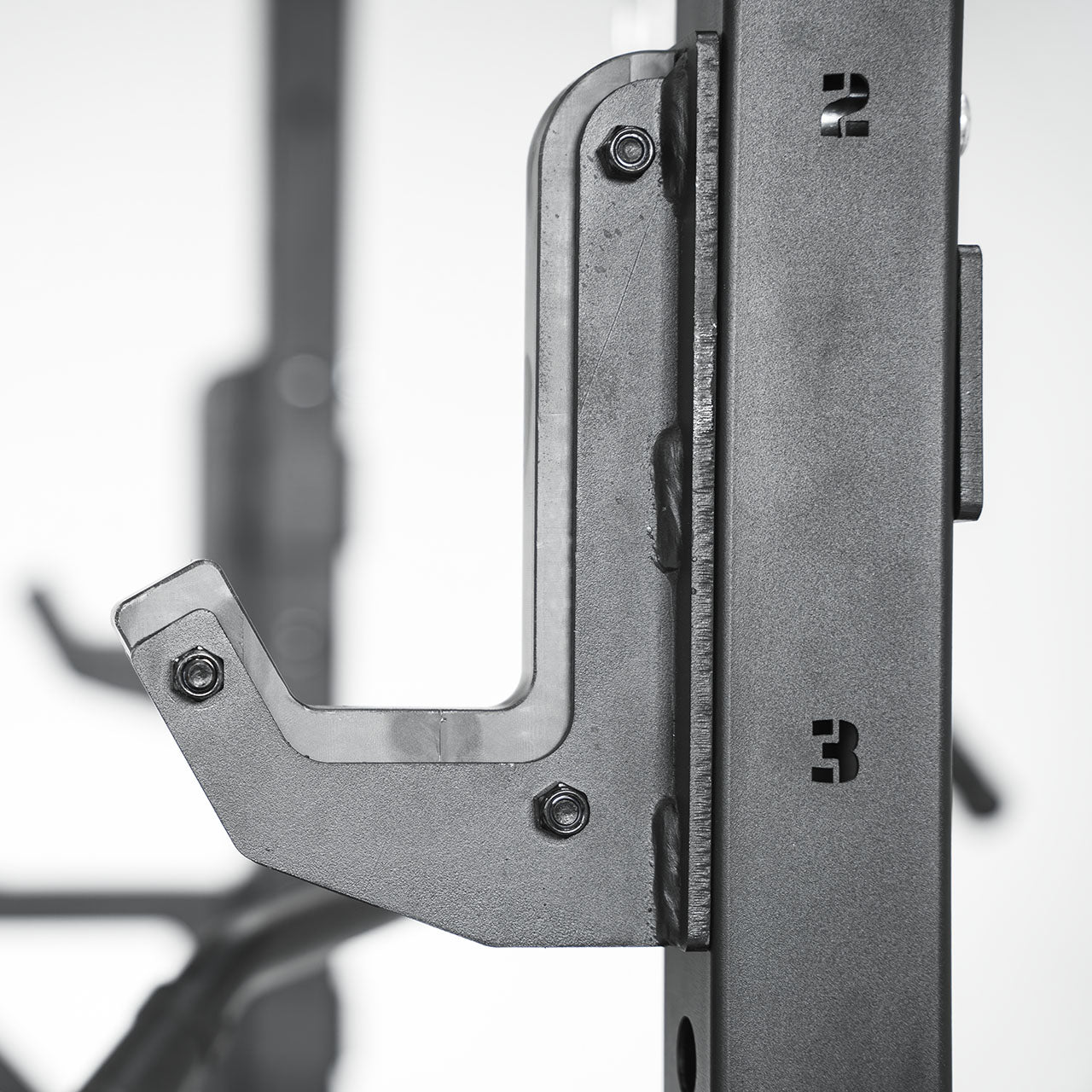 A close up of a j-hooks attachment on a half rack.
