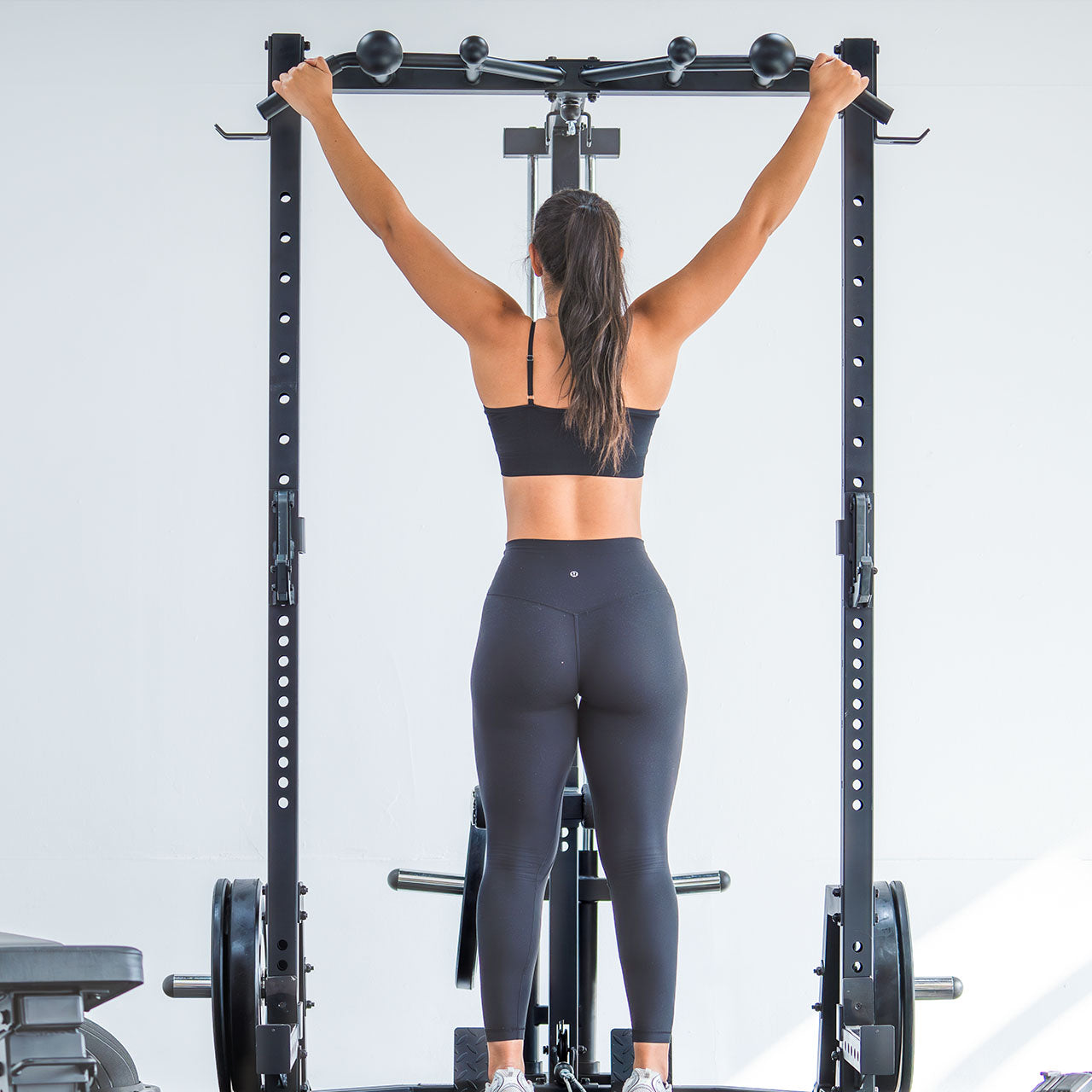 An athlete doing a pull up on a bar attachment.