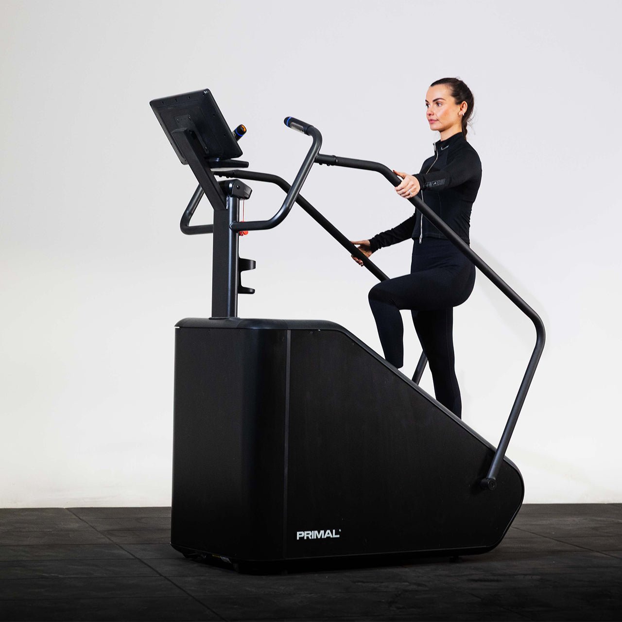 An athlete using a Primal exercise stepper machine in a studio.