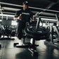 An athlete using a seated calf raise machine loaded with weight discs.