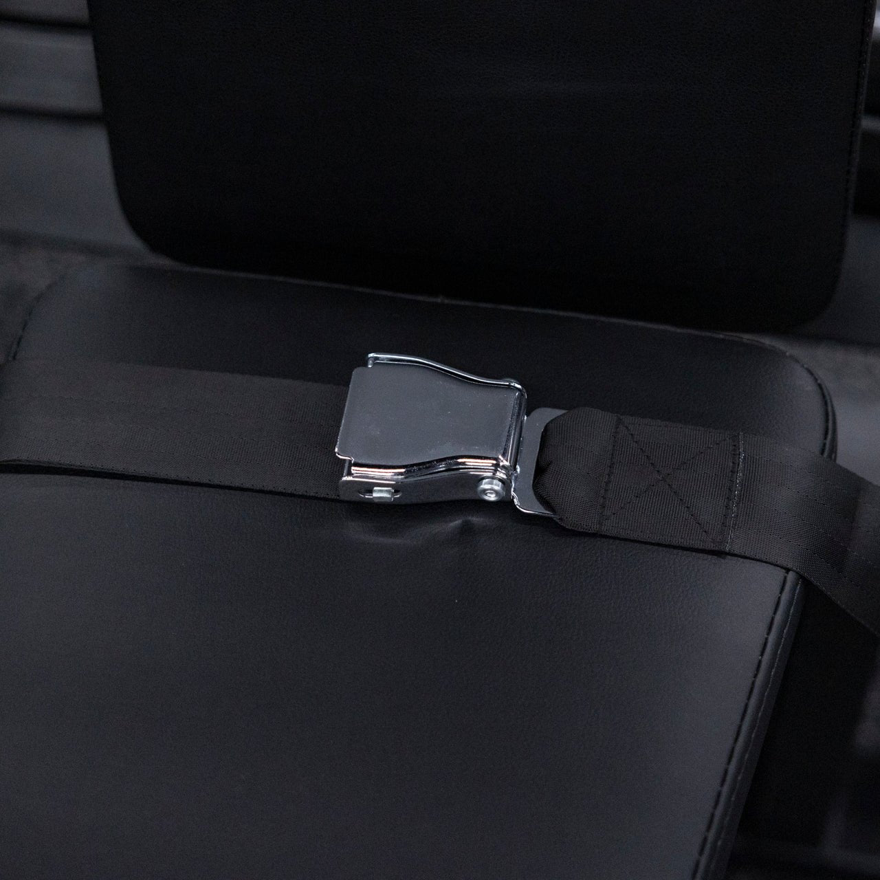 Close up view of seatbelt on plate-loaded pullover machine.