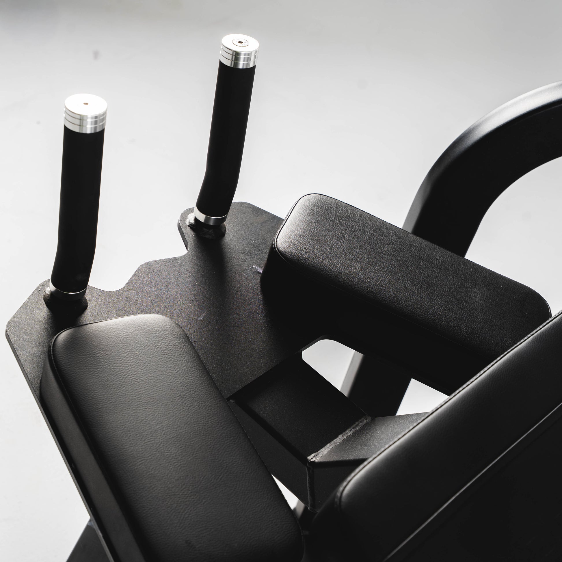 The grip handles and elbow pads on a plate loaded rear kickback machine