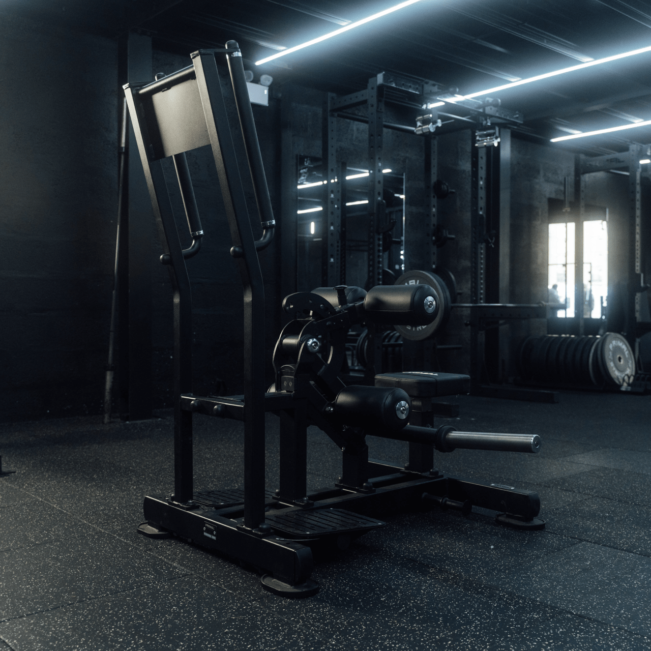 Angled view of plate-loaded standing hip thrust machine in gym.