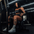Athlete sitting on plate-loaded standing hip thrust machine.