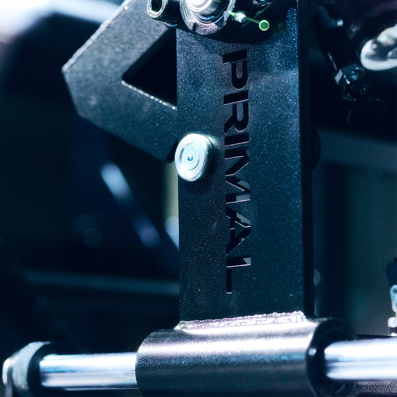 Close-up of a mechanical component with 'PRIMAL' branding on a blurred background