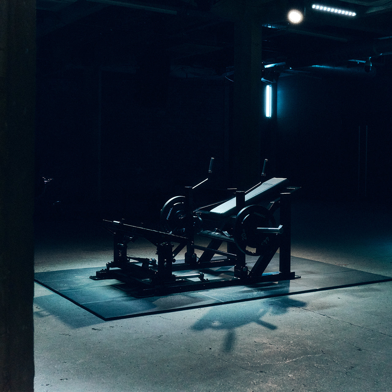 Dark and moody scene with a glute drive machine in a dimly lit room.