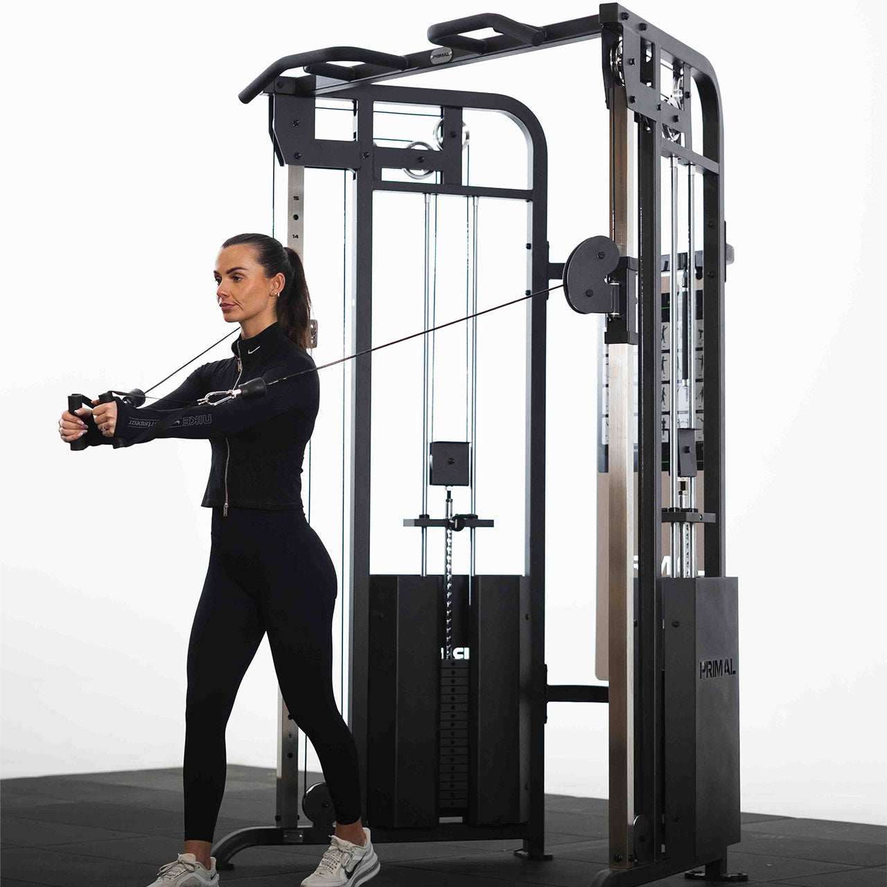 Woman exercising on a cable machine in a gym setting.