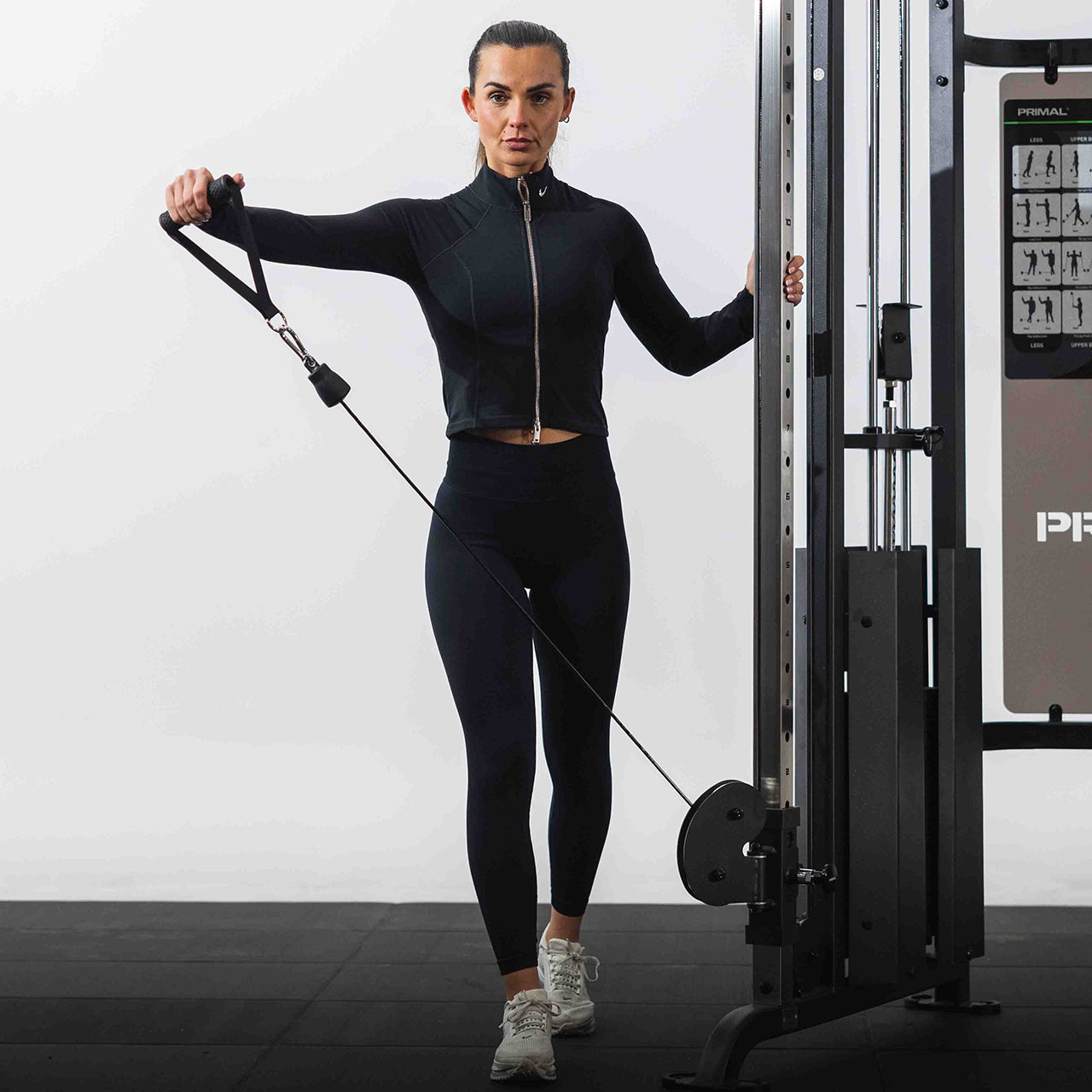 A woman exercising with a cable machine in a gym setting.