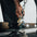An athlete adjusting the height of a plate loaded belt squat machine.