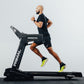 Man running on a Primal treadmill against a light gray background