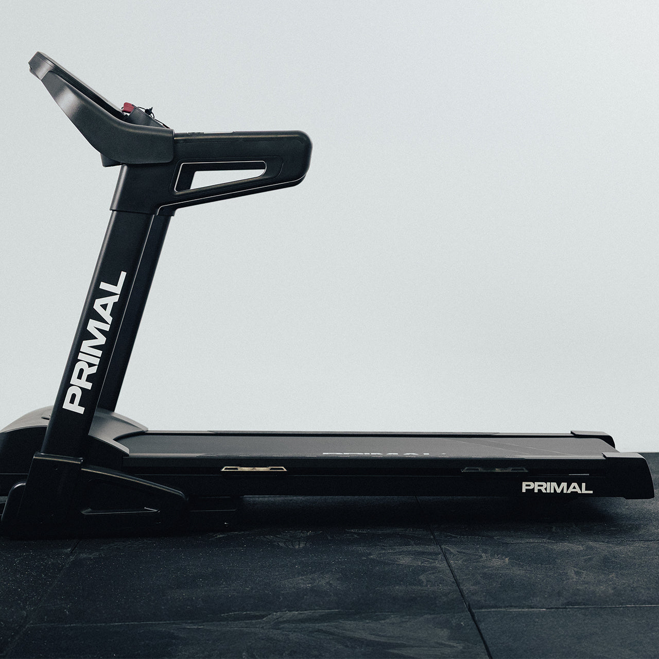 Black Primal treadmill on a grey floor with a white background