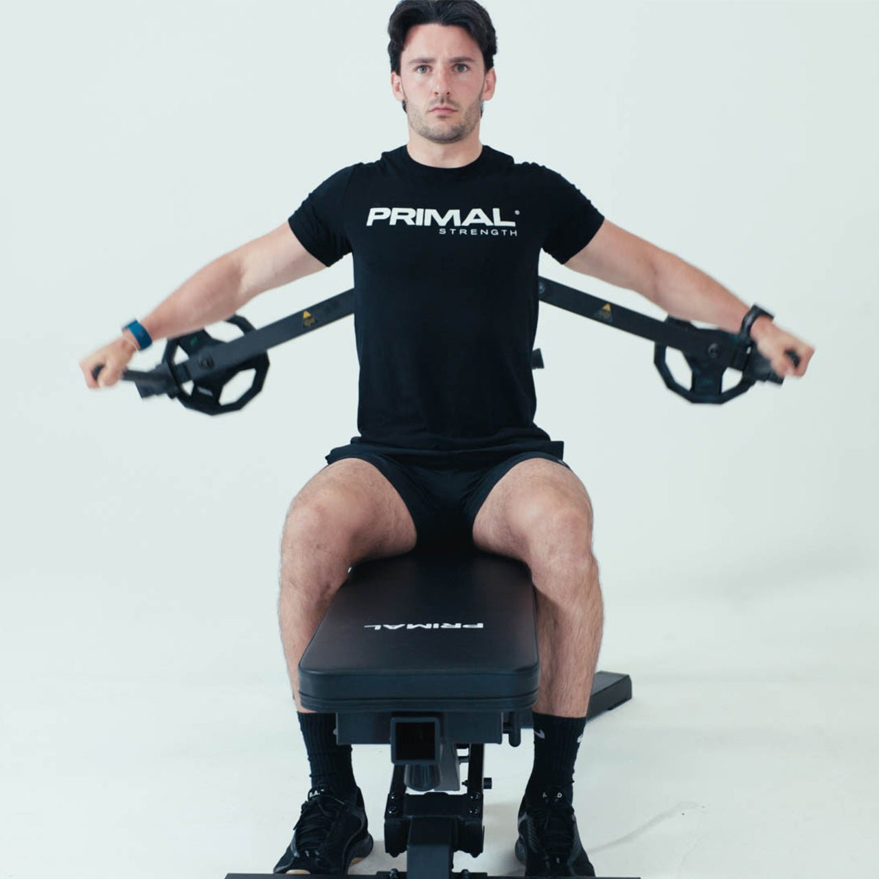 An athlete using a pec fly attachment on a weight bench.