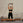 Woman exercising on a Pilates reformer machine against a brick wall.