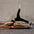 Person performing a Pilates exercise on a reformer machine against a brick wall.