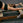 Person using a Pilates reformer machine in a gym setting.