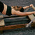 Person using a Pilates reformer machine in a gym setting.