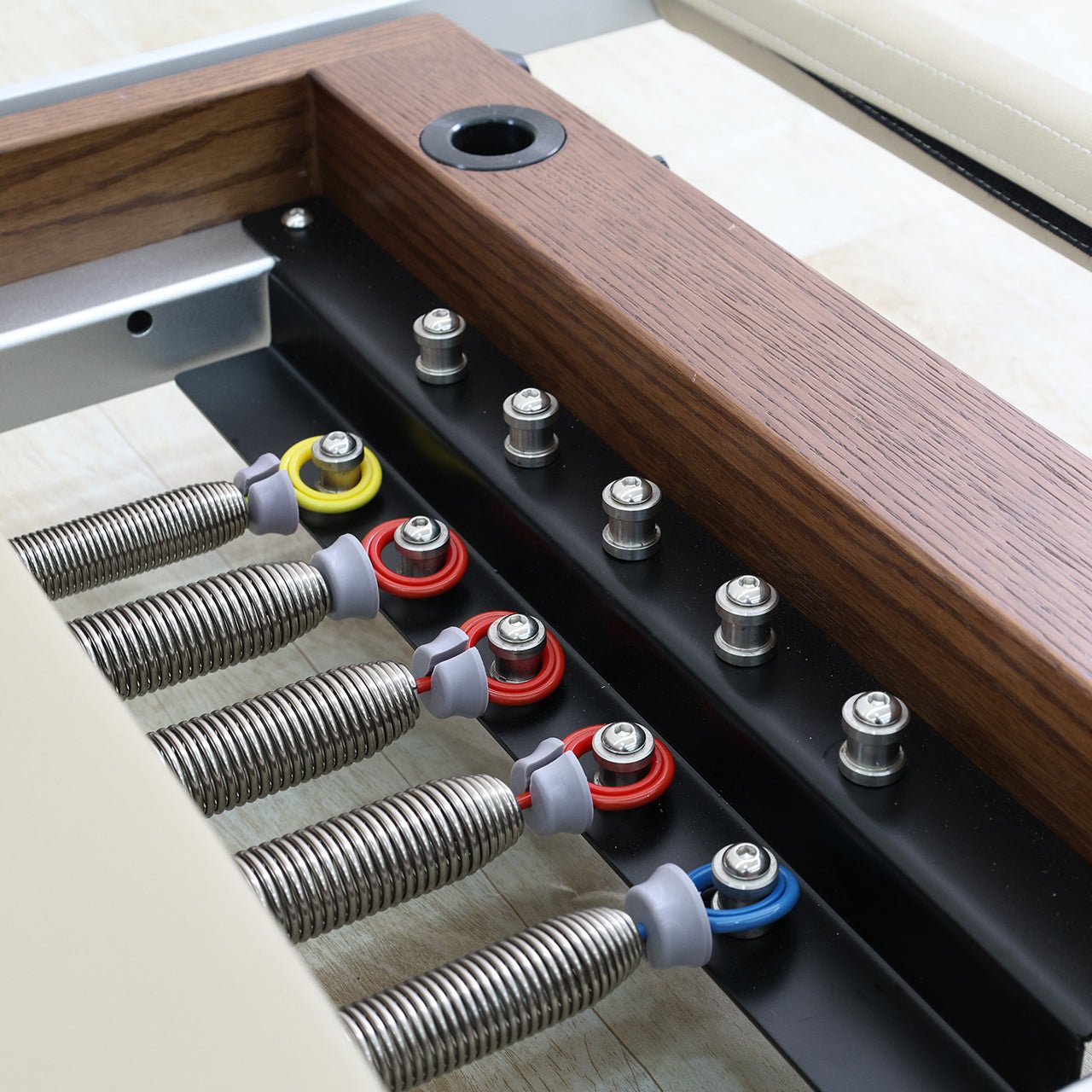 Close-up of the springs on a pilates reformer machine.