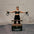 Woman exercising with Pilates reformer against a brick wall.