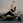 Woman exercising on a Pilates reformer machine against a brick wall.