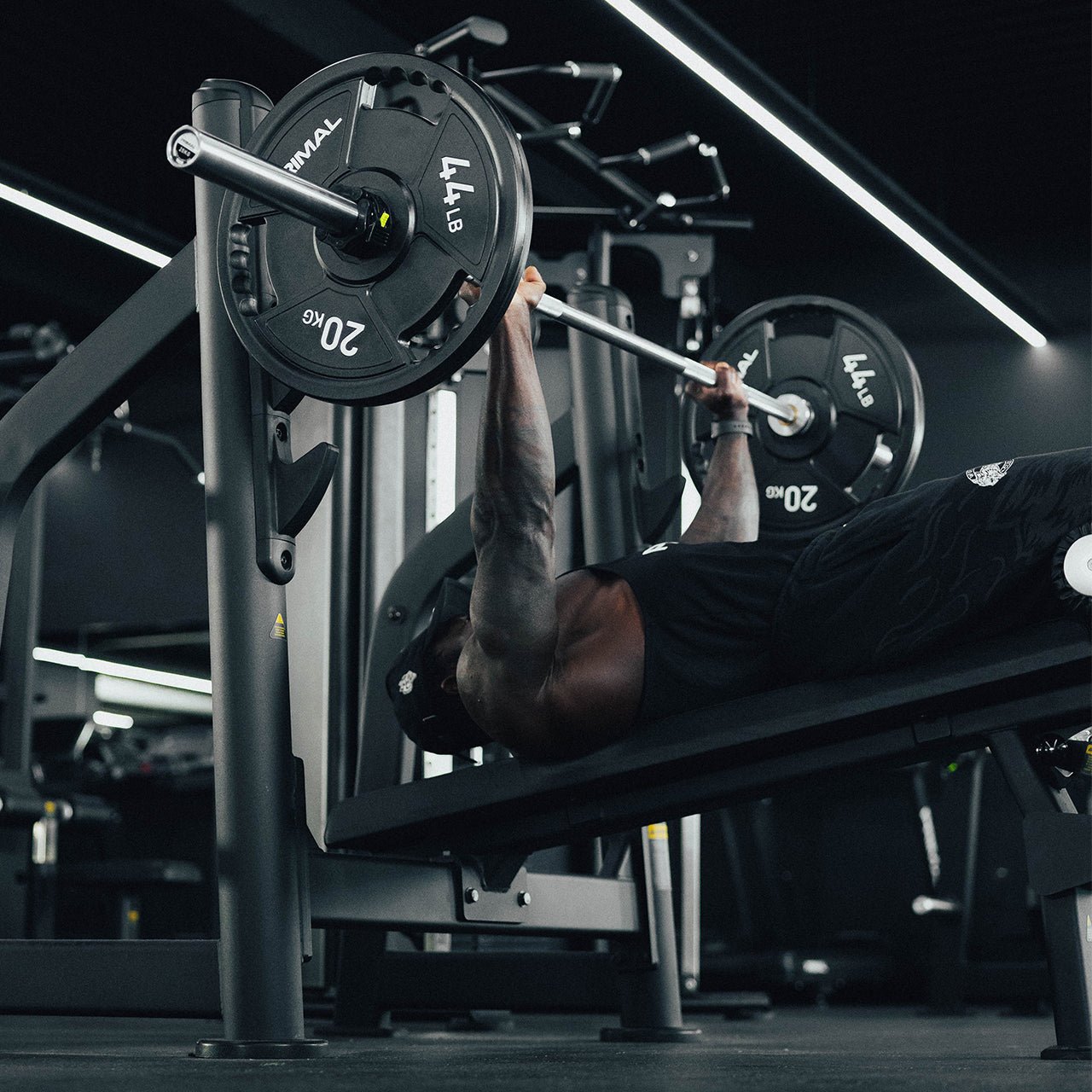 An athlete performing a decline bench press with a loaded barbell.