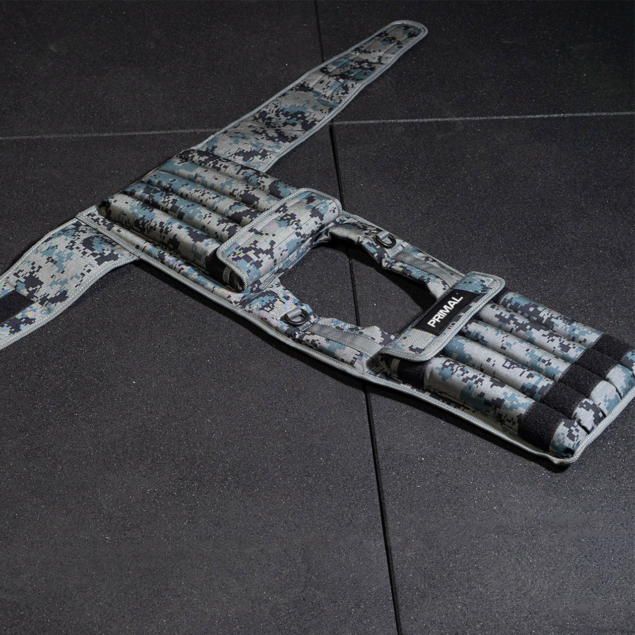 Camouflage-patterned weighted vest on a gym floor.