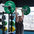 An athlete performing an overhead press with a barbell filled with bumpers plates.