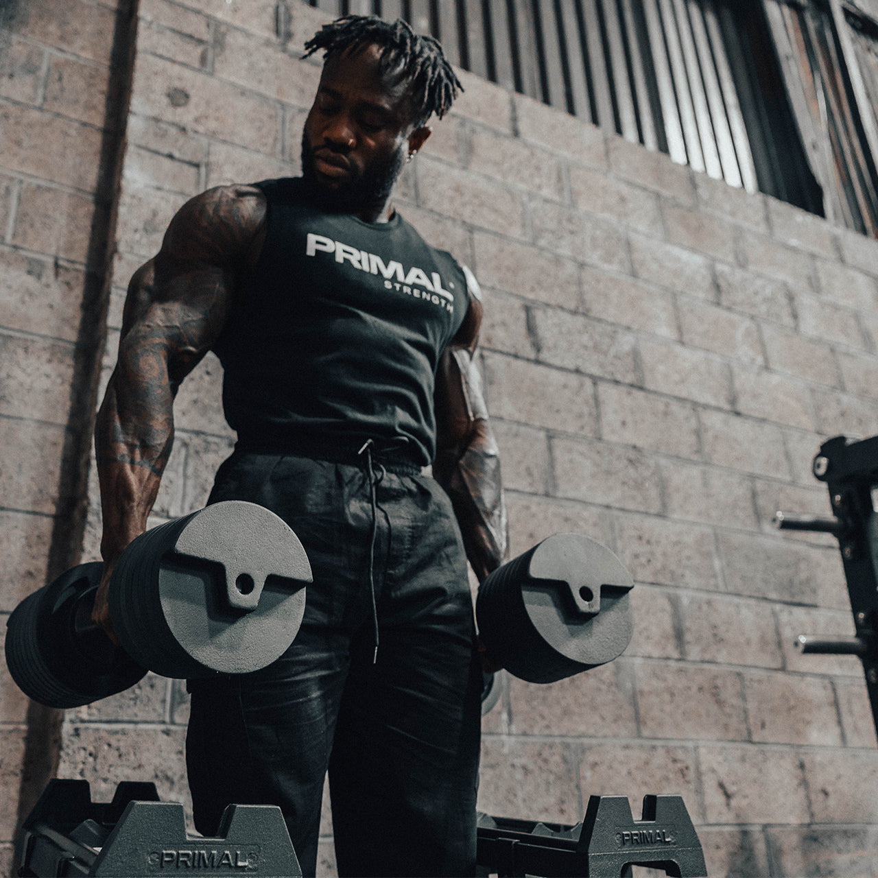 An athlete lifting a pair of 40kg adjustable dumbbells.