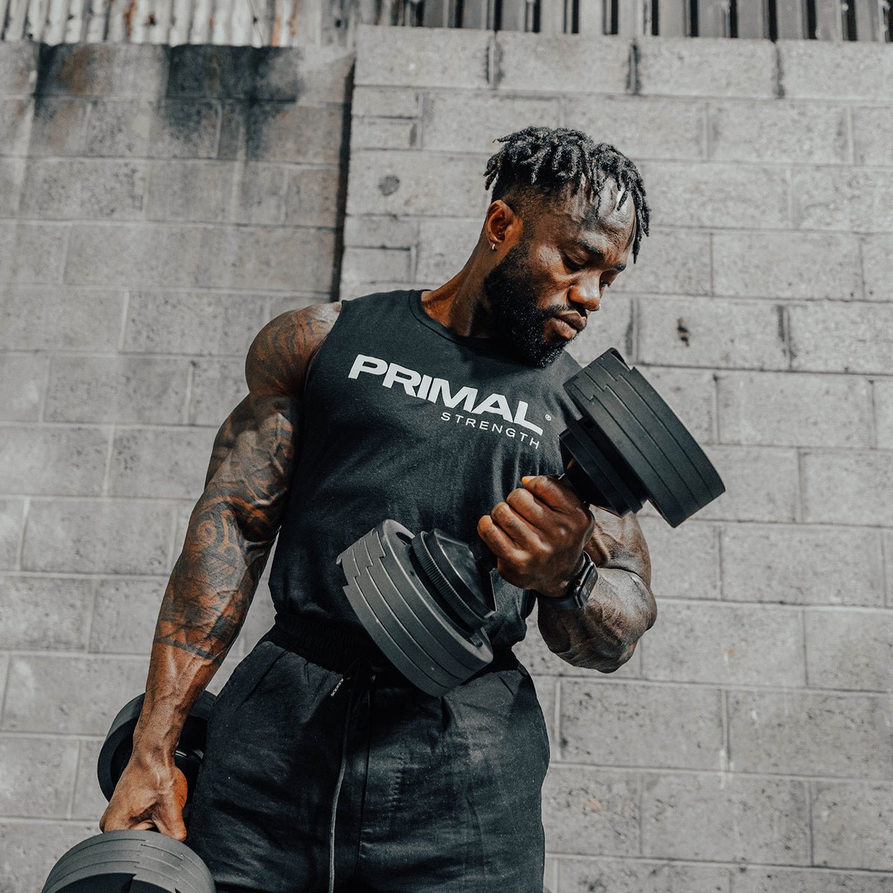 An athlete performing a bicep curl with an adjustable dumbbell.