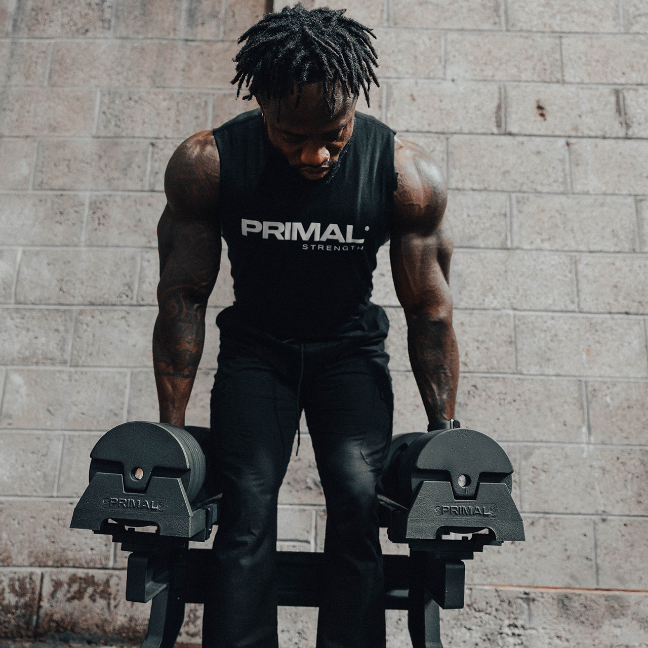 An athlete lifting a pair of 40kg adjustable dumbbells from a stand.