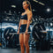 Woman lifting a barbell with 'Primal' weights in a gym setting