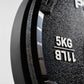 Close-up of a black weight plate with '5KG' and '11LB' text on a gray background