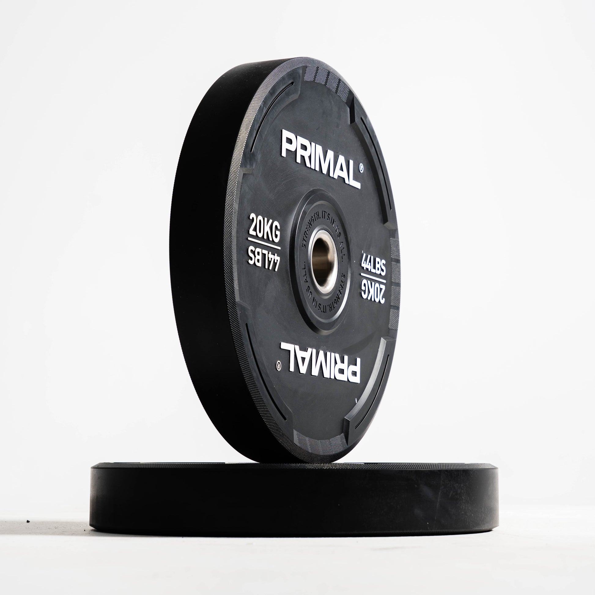 Two black Primal weight plates on a white background
