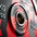 Close-up of a red and gray weight plate with 'Strength. It's in us all' text.