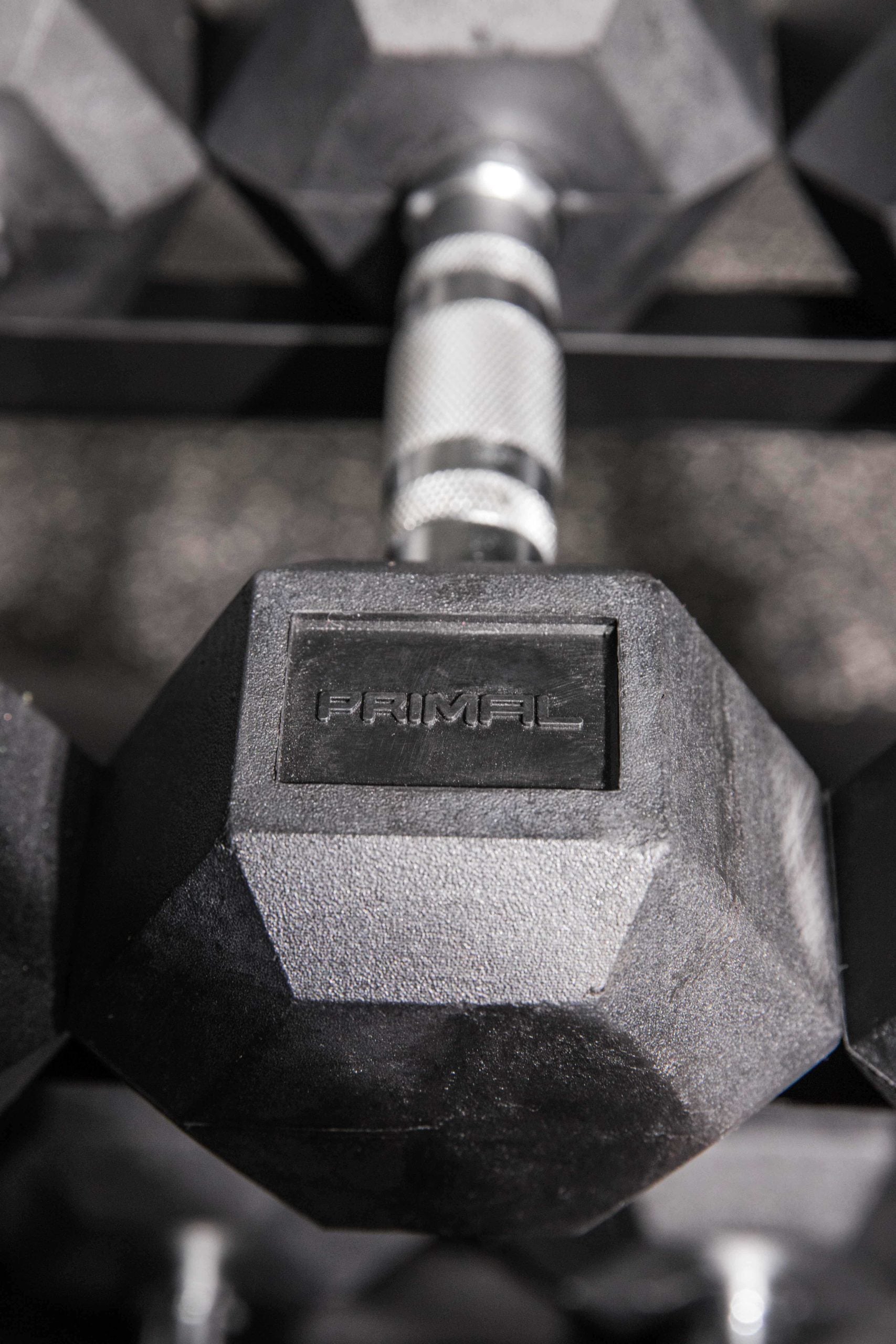 the embossed primal strength logo on a rubber hex dumbbell